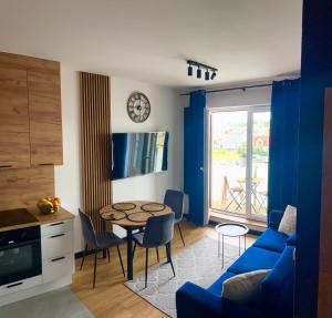 a living room with a table and a blue couch at Apartament Poznańska 1 in Suwałki