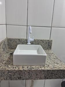 a white sink on a counter in a bathroom at Casa compartilhada em Itaúnas - Centro da Vila in Conceição da Barra