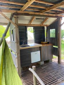 an outdoor kitchen in a pergola with a hammock at Етно хатинка та Глемпінг in Soshnikov