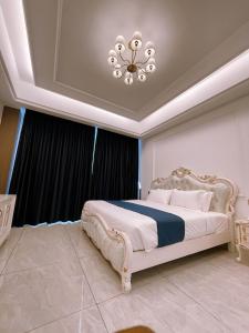 MamaDe Marii Hotel FZE的一间卧室配有一张带吊灯的大床