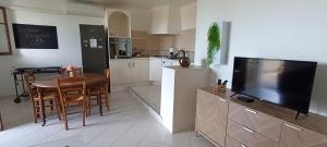 a kitchen with a dining table and a television in a kitchen at Entre mer et montagne in Monte