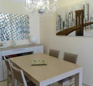 una mesa de comedor con sillas y una pintura en la pared en LA Escollera II Noja, en Noja