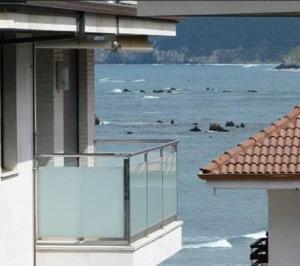 Una vista del océano desde un balcón de un edificio. en LA Escollera II Noja, en Noja