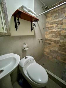a bathroom with a white toilet and a sink at Real Marquez in Trujillo