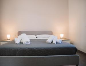 a bed with two pillows and two lamps on it at Madonnina House - Bilocale con Parcheggio vicino Rho Fiera in Bollate