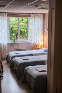 three beds in a room with two windows at Villa14 - Noisy Party Hostel in Pärnu