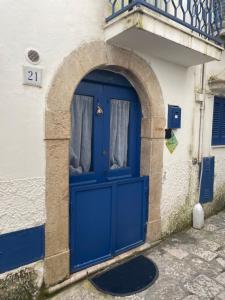 a blue door in a white building with an arch at Il cortiletto in Gaeta