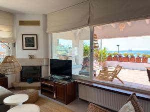 a living room with a television and a large window at Agi El Xalet in Roses