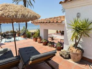 a patio with chairs and an umbrella and the beach at Agi El Xalet in Roses