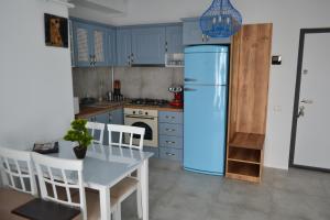 a kitchen with a blue refrigerator and a table and chairs at Apartament POK in Constanţa +6 photos