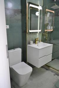 a bathroom with a toilet and a sink and a mirror at Apartament POK in Constanţa