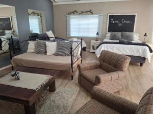 a bedroom with a bed and a couch and chairs at Myplekki in Bethlehem