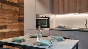 a kitchen with a table with bowls and a bottle at Olgas Chalet in Vione