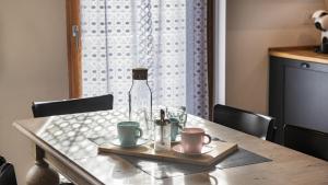 - une table en bois avec une bouteille et des tasses dans l'établissement Sesto Senso, à Ponte di Legno