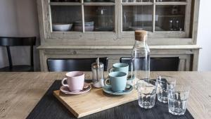 une table en bois avec une bouteille, des tasses et des verres dans l'établissement Sesto Senso, à Ponte di Legno