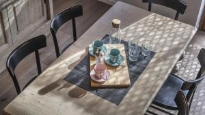 une table en bois avec une bouteille et des verres dessus dans l'établissement Sesto Senso, à Ponte di Legno