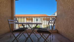 two chairs and a table on a balcony at Appartement studio - terrasse garage in Six-Fours-les-Plages