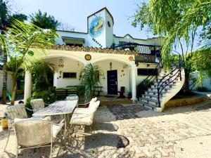 Una casa con una mesa y sillas delante de ella. en UrbanEden 'Another Day In Paradise', en Playa del Carmen