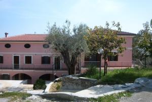 a pink house with a tree in front of it at Casa Vacanze in collina - Marina di Camerota in Lentiscosa +8 photos