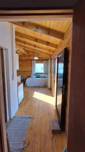 a bedroom with a bed in a wooden room at Entre Sierras y Sueños in Villa Yacanto
