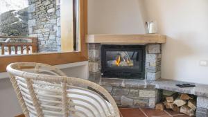 a fireplace in a living room with a chair at InstaView in Ponte di Legno