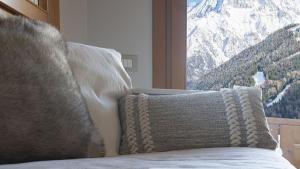 a bed with a view of a snow covered mountain at InstaView in Ponte di Legno