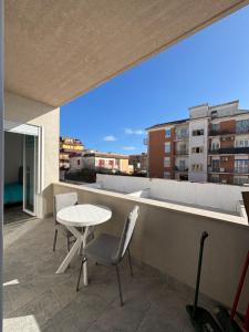 a patio with a table and chairs on a balcony at Torvajanica Antonella in Torvaianica