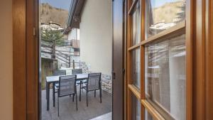 a sliding glass door with a table and chairs on a balcony at Silias Home in Vione