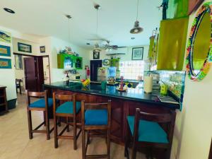 una cocina con una barra con sillas acolchadas azules en UrbanEden 'Another Day In Paradise', en Playa del Carmen