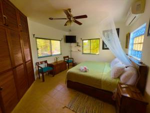 Un dormitorio con una cama con ventilador de techo. en UrbanEden 'Another Day In Paradise', en Playa del Carmen