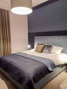 a bedroom with a large bed with a blue wall at 1 Palm Beach Penthouse - Seaview in San Pawl il Bahar