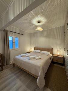 a bedroom with a large bed with towels on it at Geropalas Spacious Garden House in Vlachopoulátika