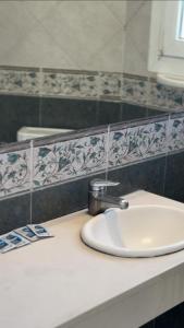 ein Badezimmerwaschbecken mit Wasserhahn auf einer Ablage in der Unterkunft Hotel Soleado in Ostende + 24 Fotos