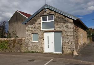 a brick building with a white door and windows at Jolie maison de centre-ville: Le Tournesac in Héricourt