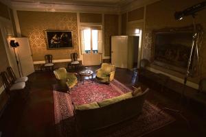 a living room with chairs and a table and a refrigerator at Palazzo Castrucci in Alvito