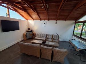 a living room with a couch and chairs and a flat screen tv at Vila D&V in 2 Mai