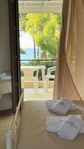 a bedroom with a bed with a view of the ocean at Ionian Sunset in Lefkada