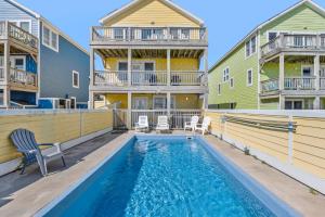 une piscine avec des chaises et une maison dans l'établissement Soleil by Village Realty, à Nags Head 24 autres photos