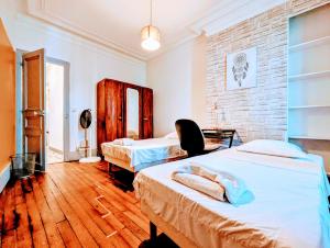 une chambre avec deux lits et un mur de briques dans l'établissement Chic apart avec parking tout près de Paris, à Saint-Denis