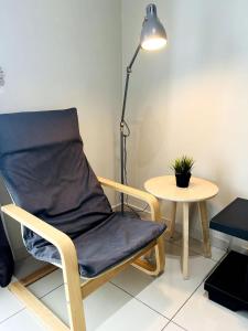 a chair sitting next to a table with a lamp at Aurora Homes at i-City - WiFi TV Box and 1 Carpark in Shah Alam