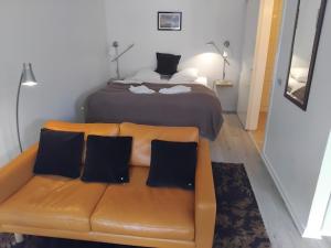 a bedroom with a bed and a brown couch with pillows at Hotel Strandvejen in Fanø
