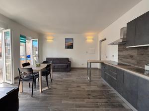 a kitchen and living room with a table and a couch at Torvajanica Antonella in Torvaianica