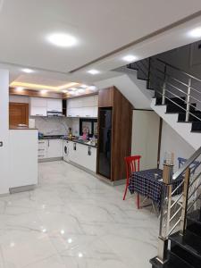 a kitchen with a staircase and a table in a room at Villa tawfik in Aghīr