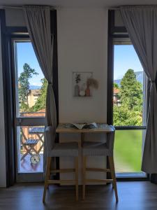 a table and a chair in front of a window at Lake & Montains View Studio with Free Parking, 1Hour from Stresa & Borromean Islands in Luino