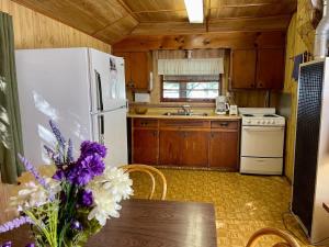 cocina con nevera blanca y mesa con flores en Balsam Lake - 3-Bedroom Cottage #3, en Kawartha Lakes