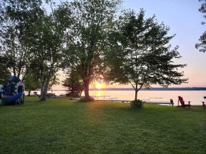 Un parque con árboles y bancos y el agua. en 3-Bedroom Cottage on Balsam Lake in Kawarthas #14, en Kawartha Lakes