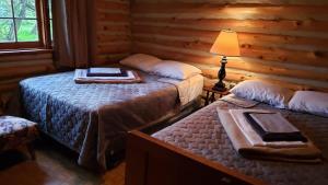a bedroom with two beds in a log cabin at 2-Bedroom - Balsam Lake Cottages Resort #12 in Kawartha Lakes