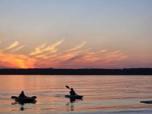 two people in canoes on a lake at sunset at 2-Bedroom - Balsam Lake Cottages Resort #12 in Kawartha Lakes