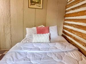 Una cama con una almohada roja y blanca. en 1-Bedroom Balsam Lake Cottage #9, en Kawartha Lakes