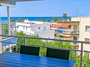 a blue table on a balcony with a view of the ocean at LITORAL COSTA DORADA - CORAL Only families in Cambrils